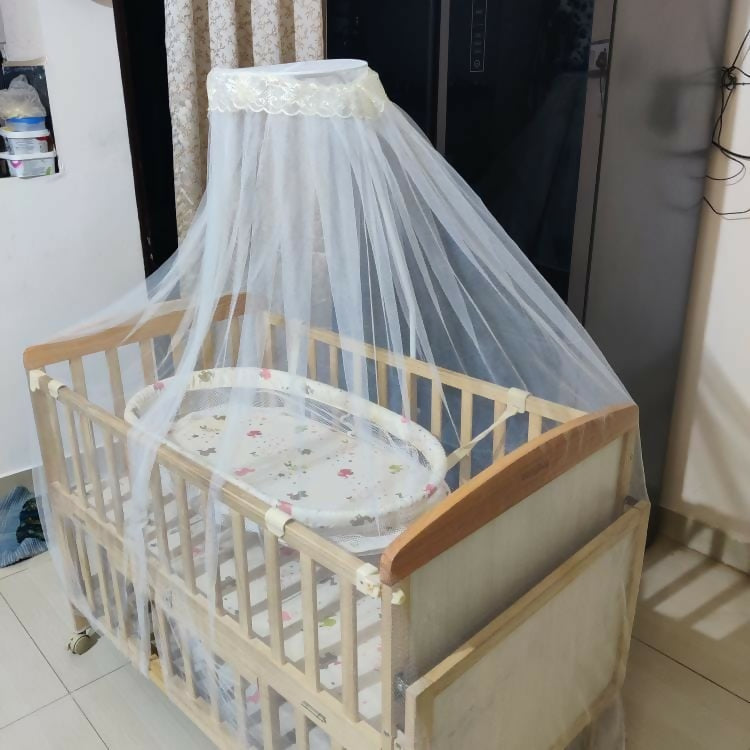 Ensure your baby's comfort and safety with the BABYHUG Kelly Wooden Crib/Cot – featuring a detachable bassinet, mosquito net, and smooth-rolling casters for easy mobility and convenience.