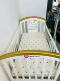 Shop Huny Huny Convertible Baby Cot – Wooden crib with storage, teething rails, wheels, and adjustable height.