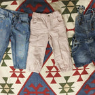 Three pairs of children's pants on a patterned rug