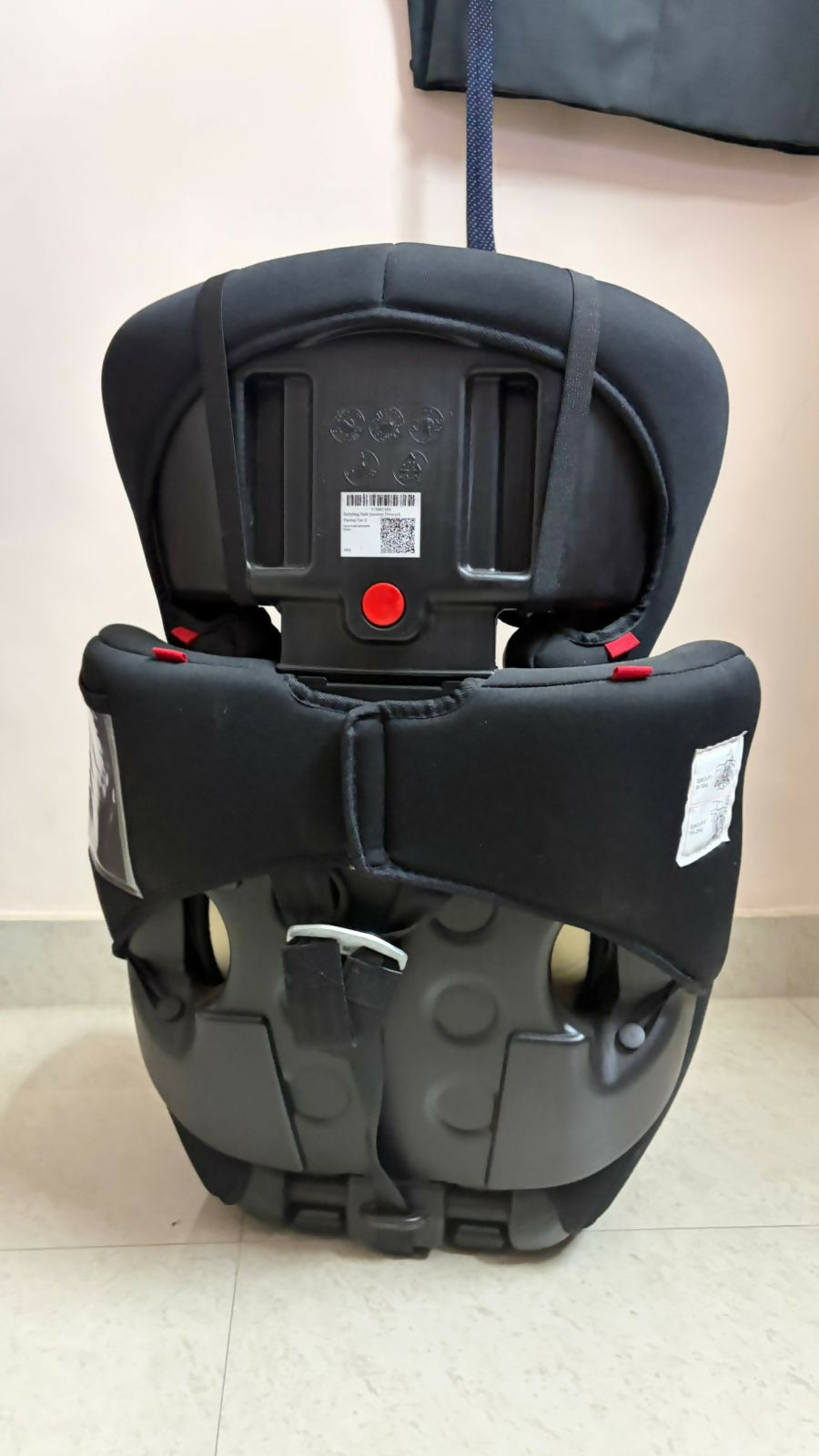Black and gray car seat on a light-colored floor