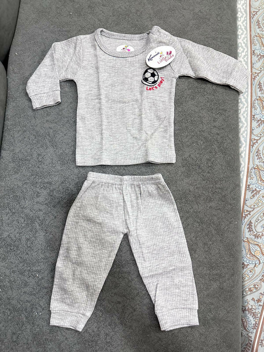 Gray baby outfit with long-sleeve top and pants on a textured surface