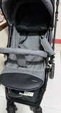 Gray stroller with a visible brand logo on a white floor.