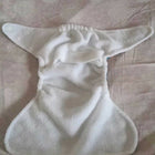 White cloth diaper on a pink textured surface