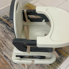 Baby high chair on a tiled floor with a rug underneath