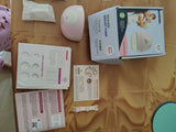 Nursing bra, breast pump, and accessories on a brown surface
