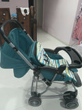 Blue baby stroller with a striped cover on a tiled floor.