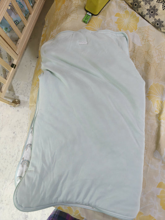 Light blue baby wrap on a floral-patterned bed