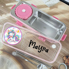 Stainless steel lunch box with pink accents and personalized name on a wooden surface.