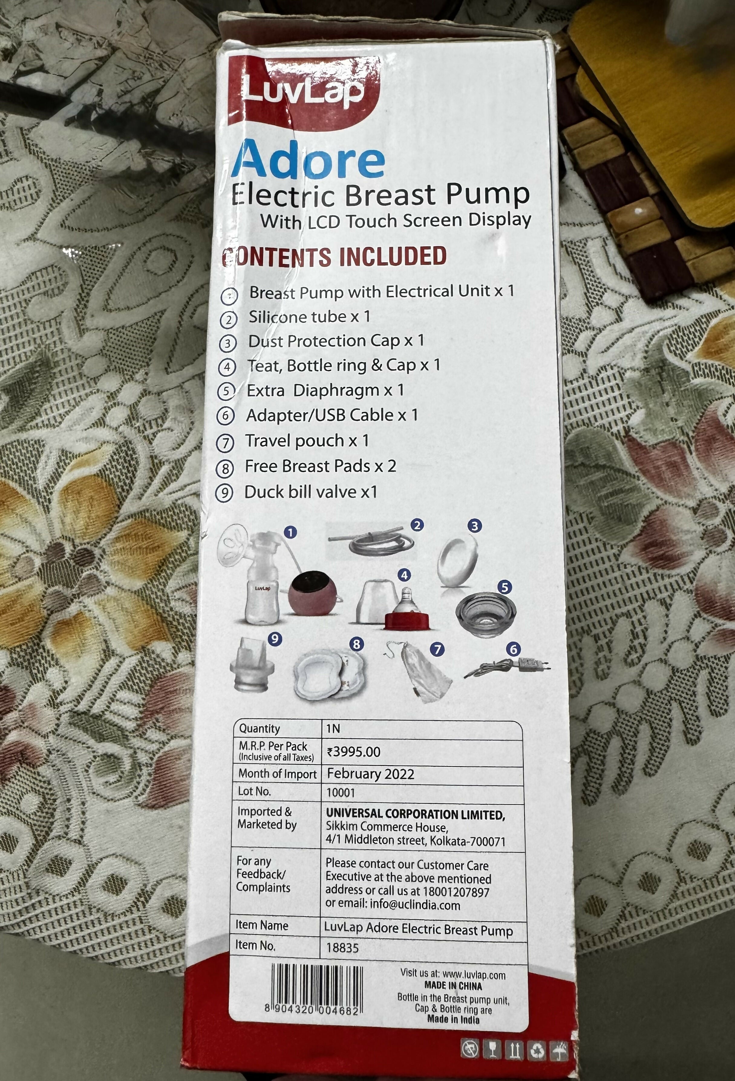 Luvlap Adore Electric Breast Pump packaging with detailed contents list on a floral tablecloth.