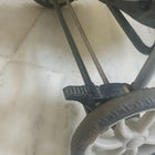 Close-up of a stroller wheel and metal frame on a light background